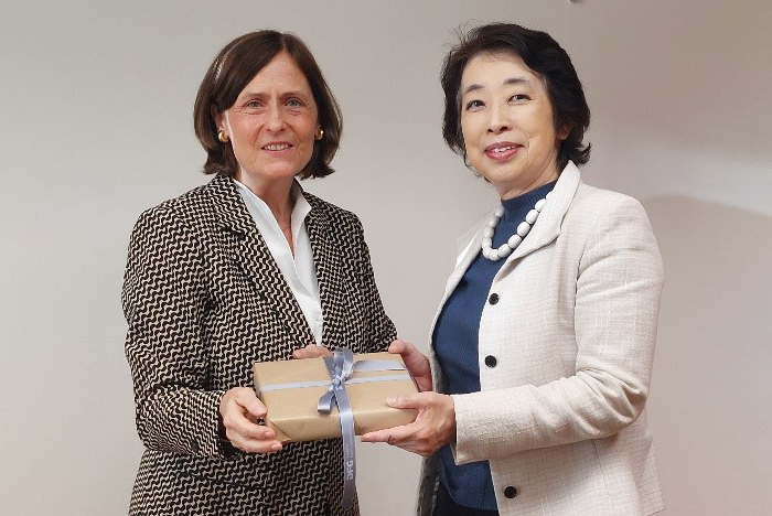 Professorin Dr. Katja Becker und I.E. Mitsuko Shino stehen nebeneinander und halten ein eingepacktes Geschenk in ihren Händen.